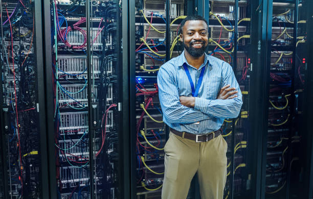 IT professional standing in front of network server racks